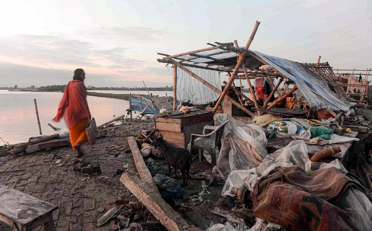 A villager walks past a damaged house, in the aftermath of Cyclone Amphan, in South 24 Paraganas district of West Bengal. (PTI Photo)