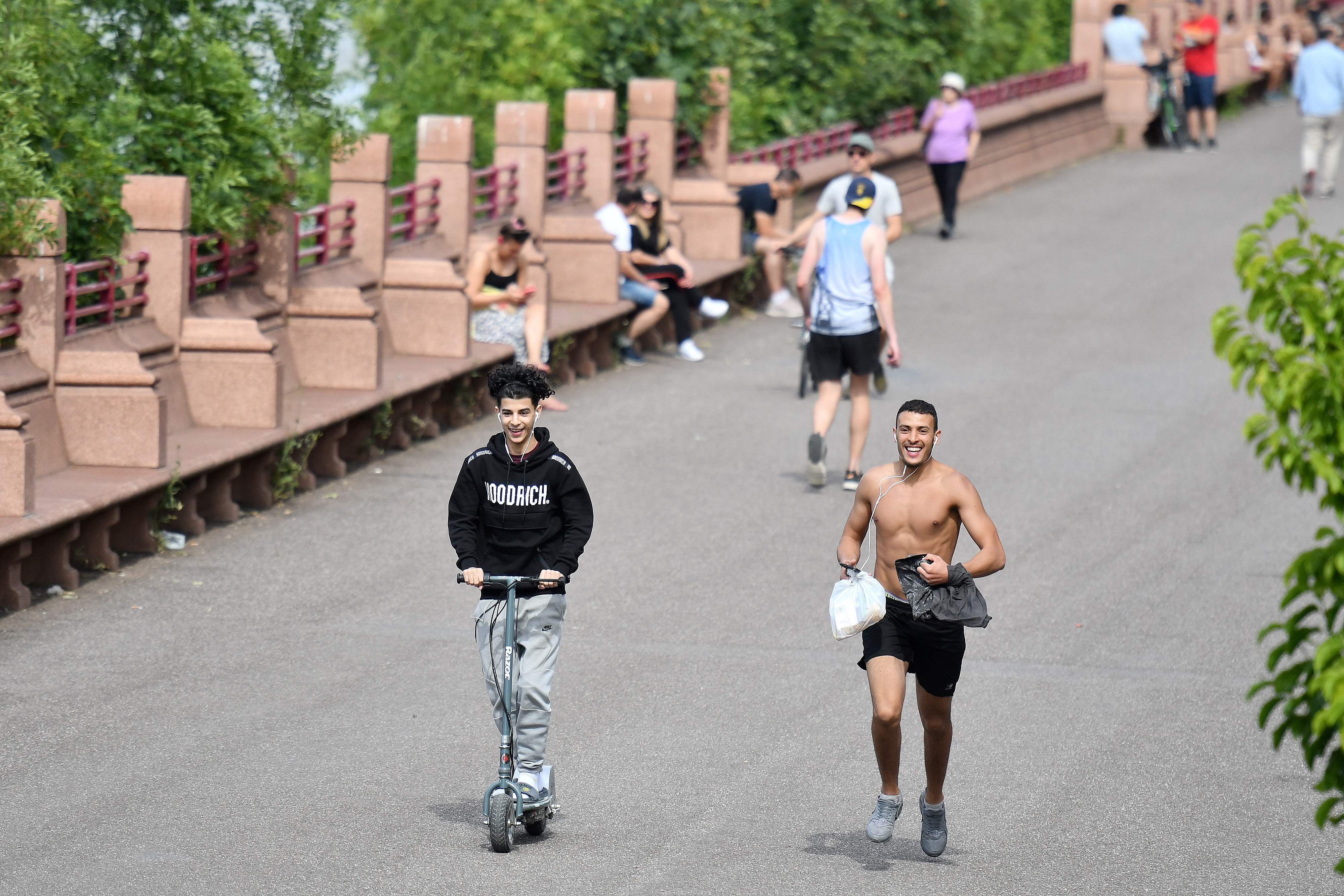 People enjoy the sunshine as they exercise in Battersea Park, near the River Thames in London on June 2, 2020, as warm weather continues during the coronavirus lockdown. (Credit: AFP Photo)