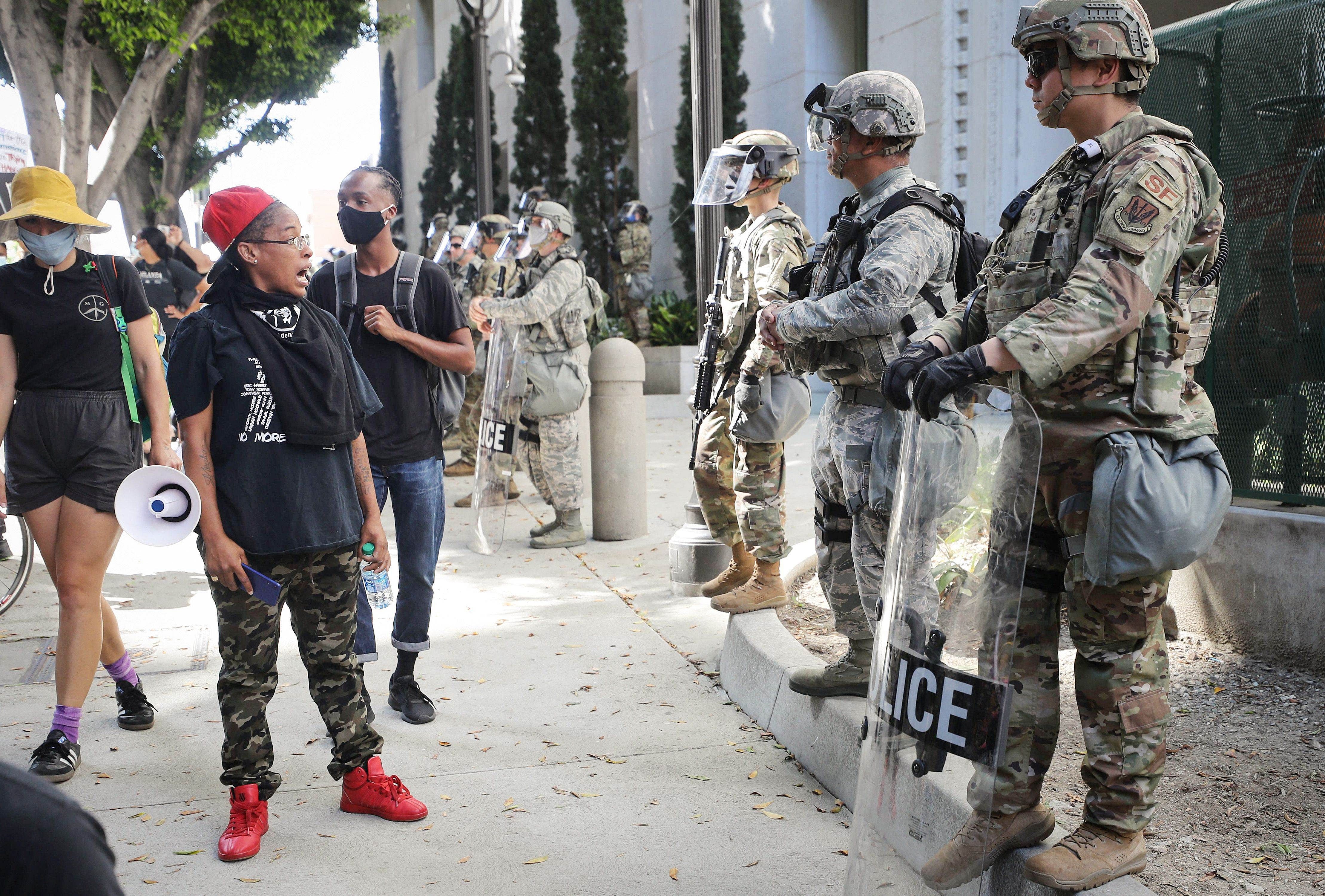 A protestor speaks to National Guard troops posted outside the District Attorney's office during a peaceful demonstration over George Floyd's death. Credit: AFP