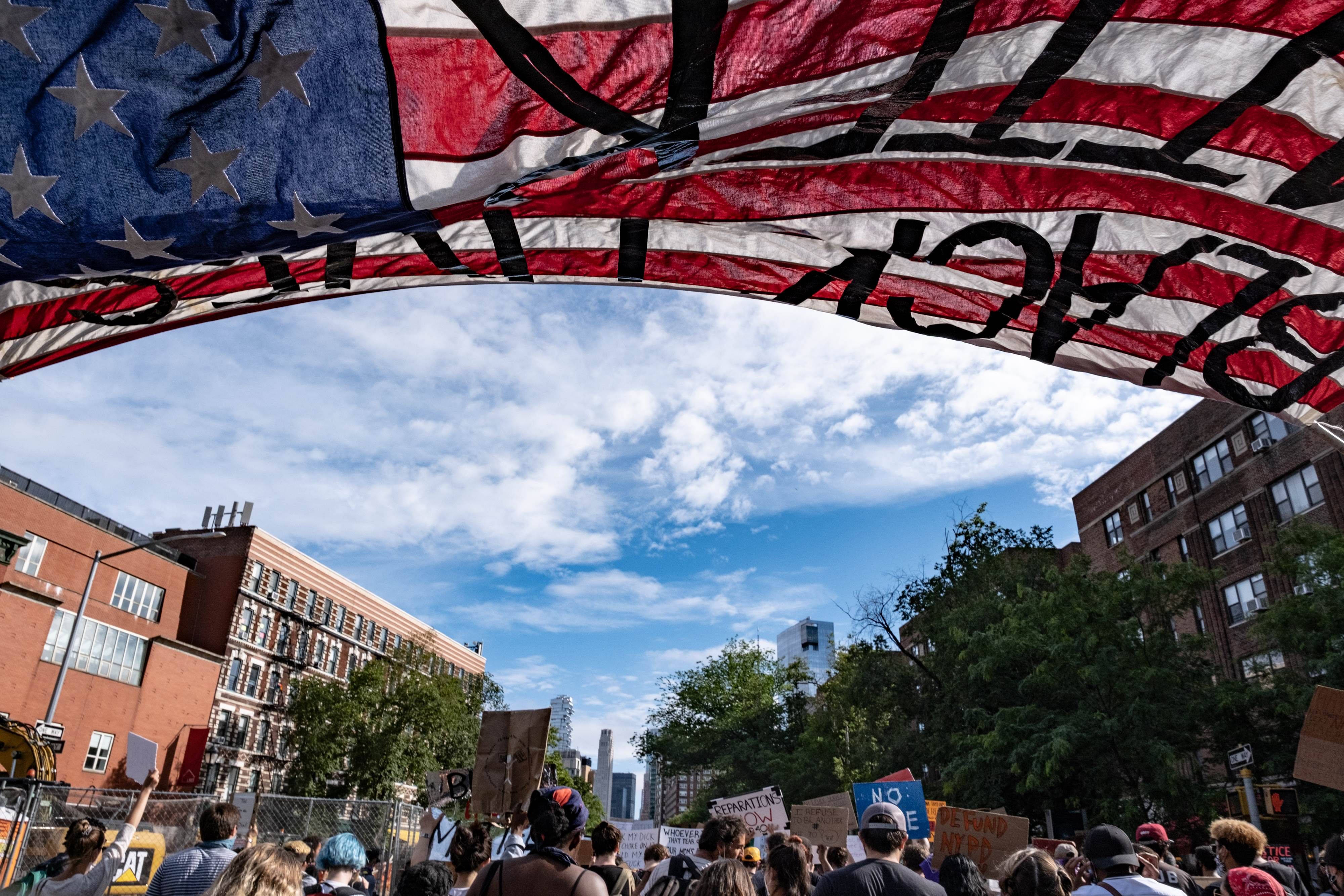 People walk under an American flag reading Black Lives Matter during a protest on June 18, 2020 in New York City. Credit: AFP Photo