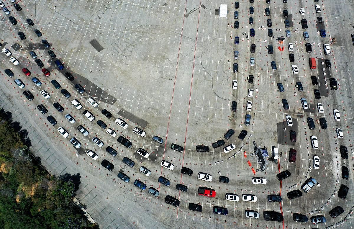 An aerial view of people in cars lined up to be tested for COVID-19 in a parking lot at Dodger Stadium amid the coronavirus pandemic in Los Angeles, California.  Credit/AFP Photo