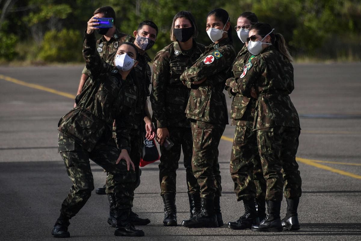 Members of the Brazilian Armed Forces medical service pose for a selfie at a military base in Boa Vista, Roraima state, Brazil. Credit/AFP Photo