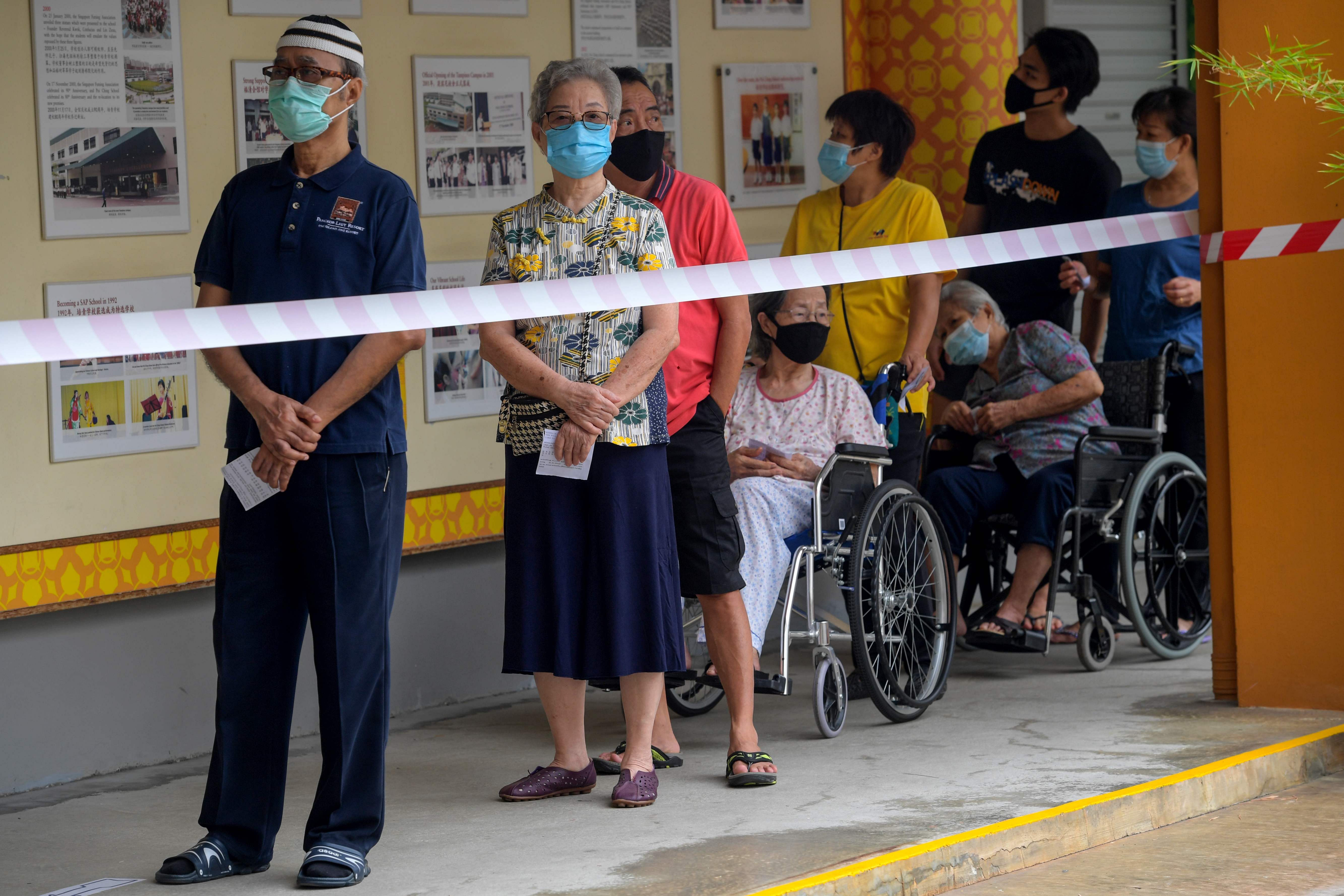 Voters wearing face masks wait to cast their ballots during the general election in Singapore. Credits: AFP Photo