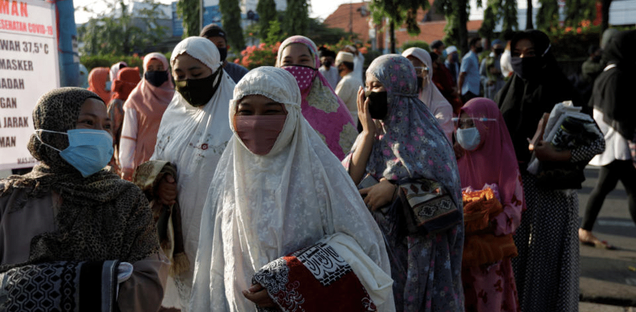 Face masks wearing Indonesian Muslim women walk to attend Eid al-Adha prayers on the street in Jakarta, during the outbreak of the coronavirus disease. Credit: Reuters