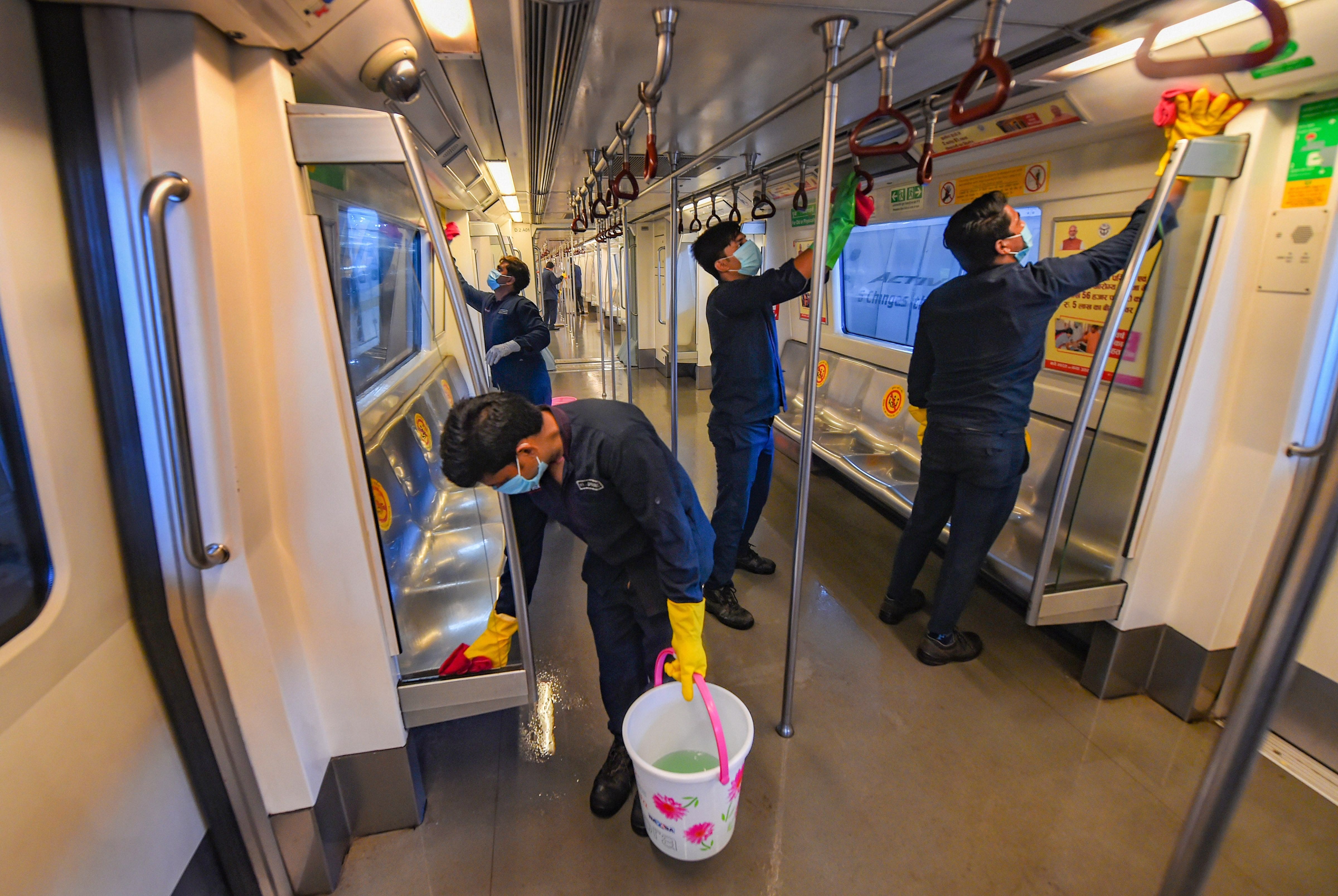 Workers sanitise a metro train as Delhi Metro Rail Corporation (DMRC) gears up to resume its services from Sept 7 with certain restrictions. Credit: PTI