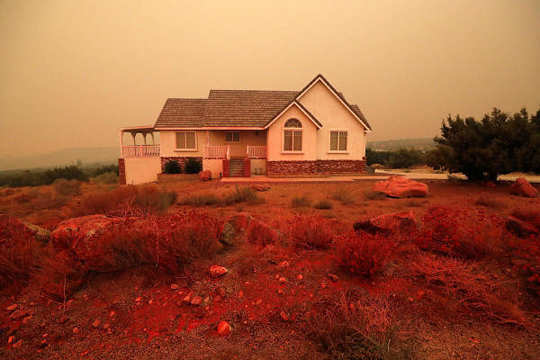 A house is seen after fire retardant is dropped from a tanker, as the Bobcat Fire burns near Juniper Hills, California, U.S. Credit: Reuters Photo