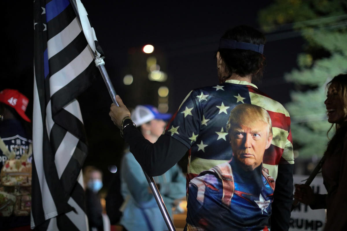 Supporters stand for a vigil for US President Donald Trump outside of Walter Reed National Military Medical Center, where Trump is being treated for coronavirus in Bethesda, Maryland. Credit: Reuters Photo