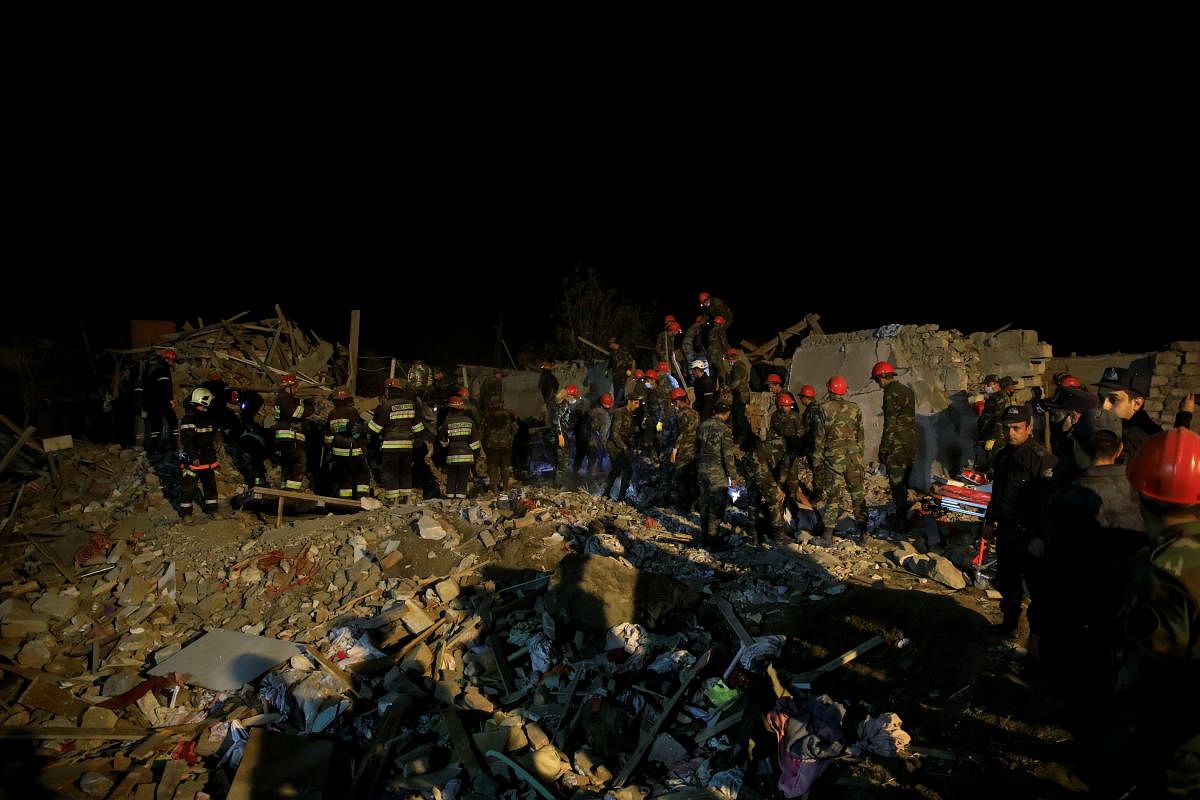 Search and rescue teams work on the blast site hit by a rocket during the fighting over the breakaway region of Nagorno-Karabakh, in the city of Ganja, Azerbaijan. Credit: Reuters Photo