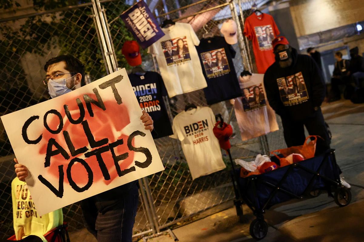 A demonstrator holds a placard as people gather at Black Lives Matter Plaza near the White House during Election Day in Washington, US. Credit: Reuters Photo