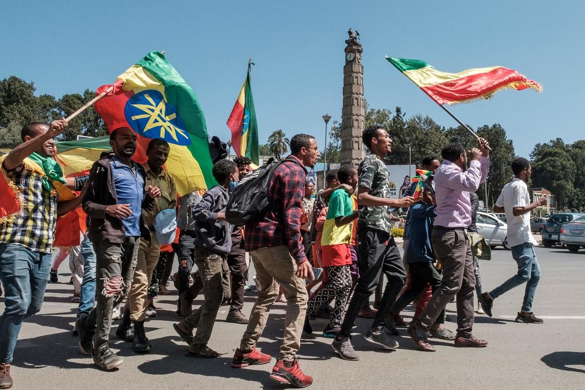 People carry Amhara flags and Ethiopian national flags in the streets after a national call to stand in honour of the Ethiopian National Defence Forces, in Addis Ababa. The United Nations on November 17, 2020 expressed alarm at the "large-scale humanitarian crisis" developing on the border between Sudan and Ethiopia, where thousands of people are fleeing the ongoing fighting in northern Tigray every day. Credit: AFP Photo
