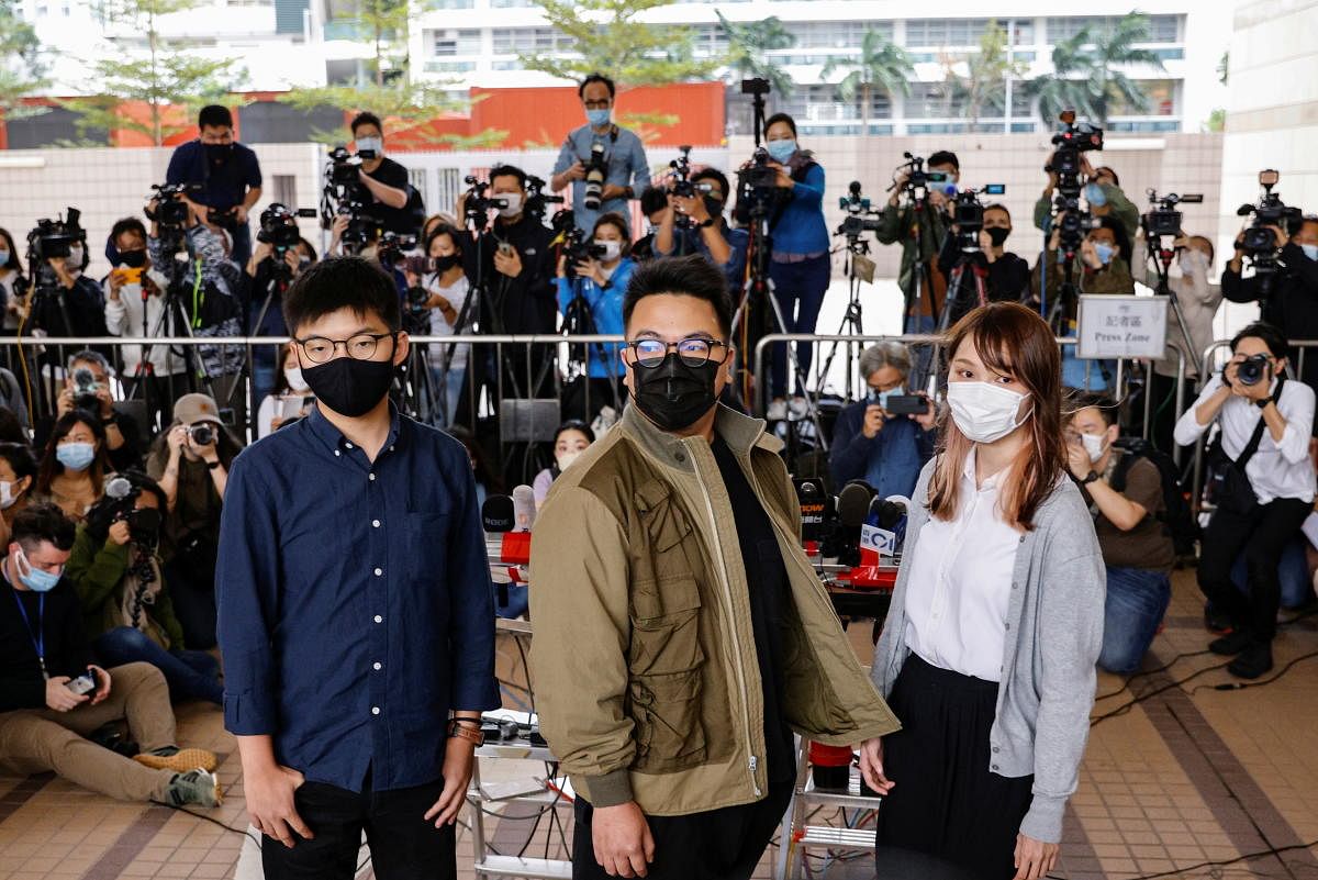 Pro-democracy activists Ivan Lam, Joshua Wong and Agnes Chow arrive at the West Kowloon Magistrates' Courts to face charges related to illegal assembly stemming from 2019, in Hong Kong. Credit: Reuters Photo