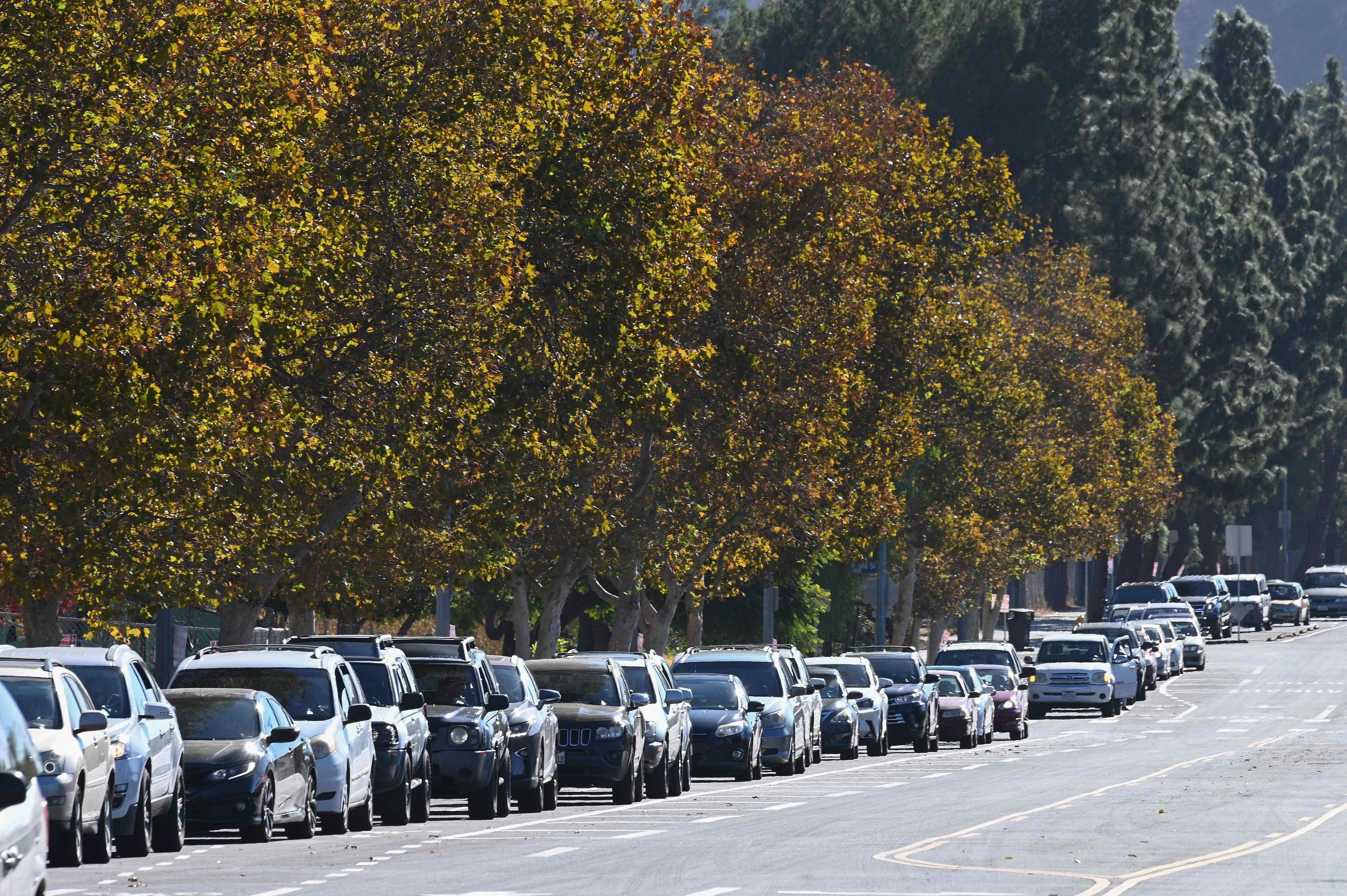 Cars wait in line to receive free groceries for people experiencing food insecurity due to the coronavirus pandemic. Credit: AFP Photo