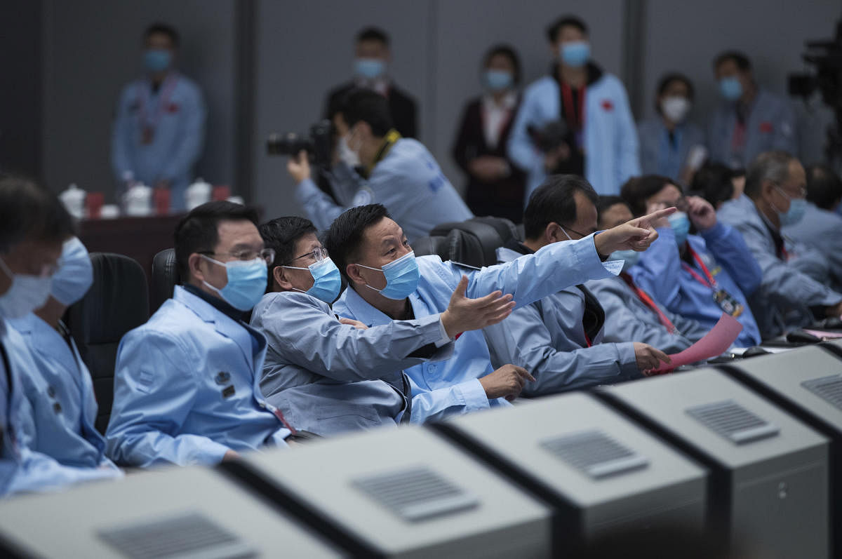 Technical personnel at the Beijing Aerospace Control Center (BACC) in Beijing, watch as their lunar probe lifted off from the on moon Thursday night with a cargo of lunar samples on the first stage of its return to Earth. Credit: AP/PTI Photo Photo