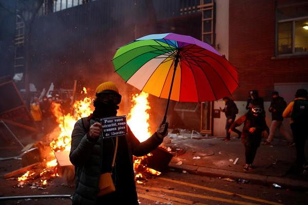 A demonstrator holds an umbrella and a sign reading "For your safety you will have no more freedoms" during a protest against the "Global Security Bill'', that right groups say would make it a crime to circulate an image of a police officer's face and would infringe journalists' freedom in the country, in Paris. Credit: Reuters