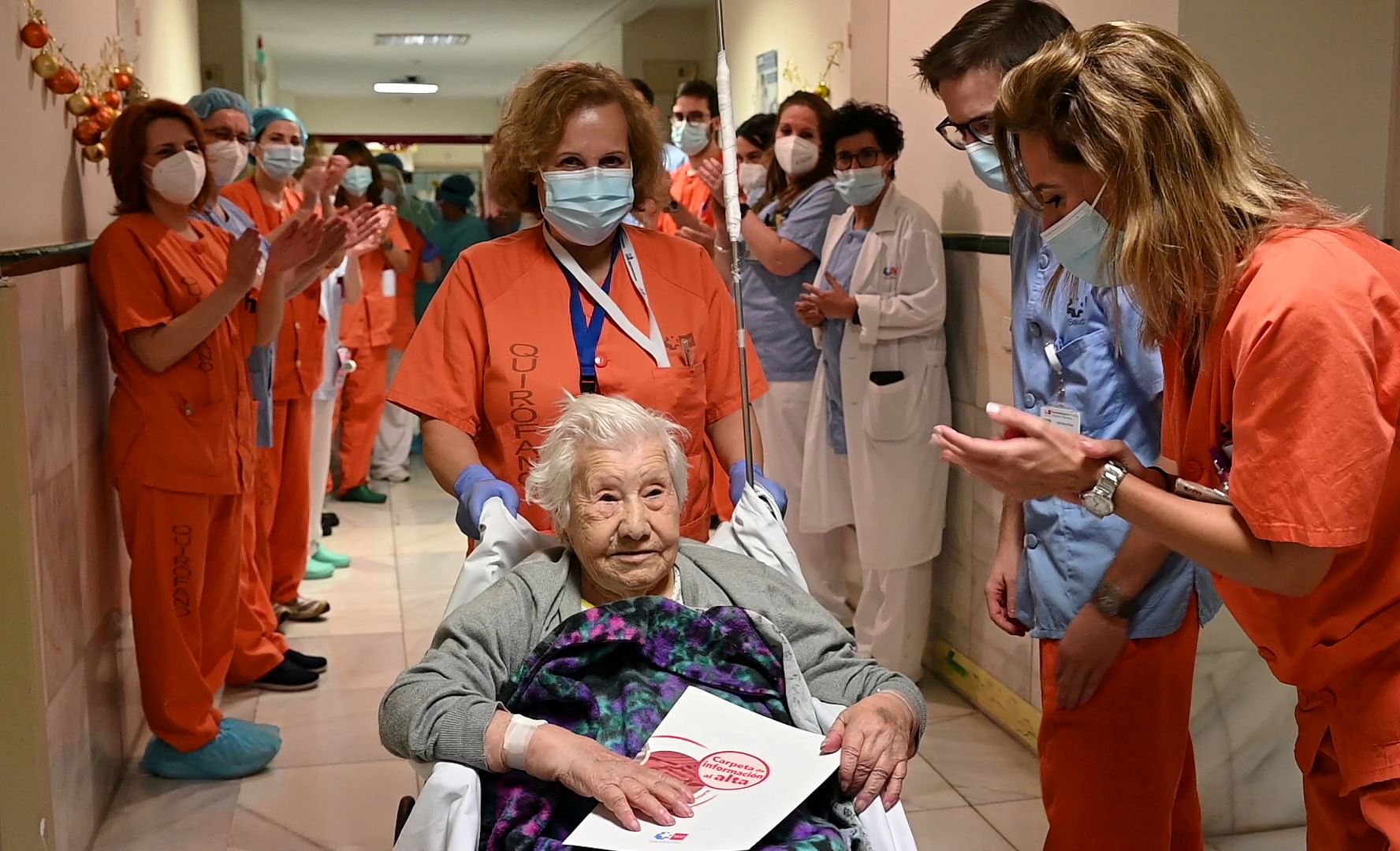 Health workers salute Elena, 104, as she leaves the Gregorio Maranon hospital, after being treated for the coronavirus disease and discharged, in Madrid, Spain. Credit: Reuters