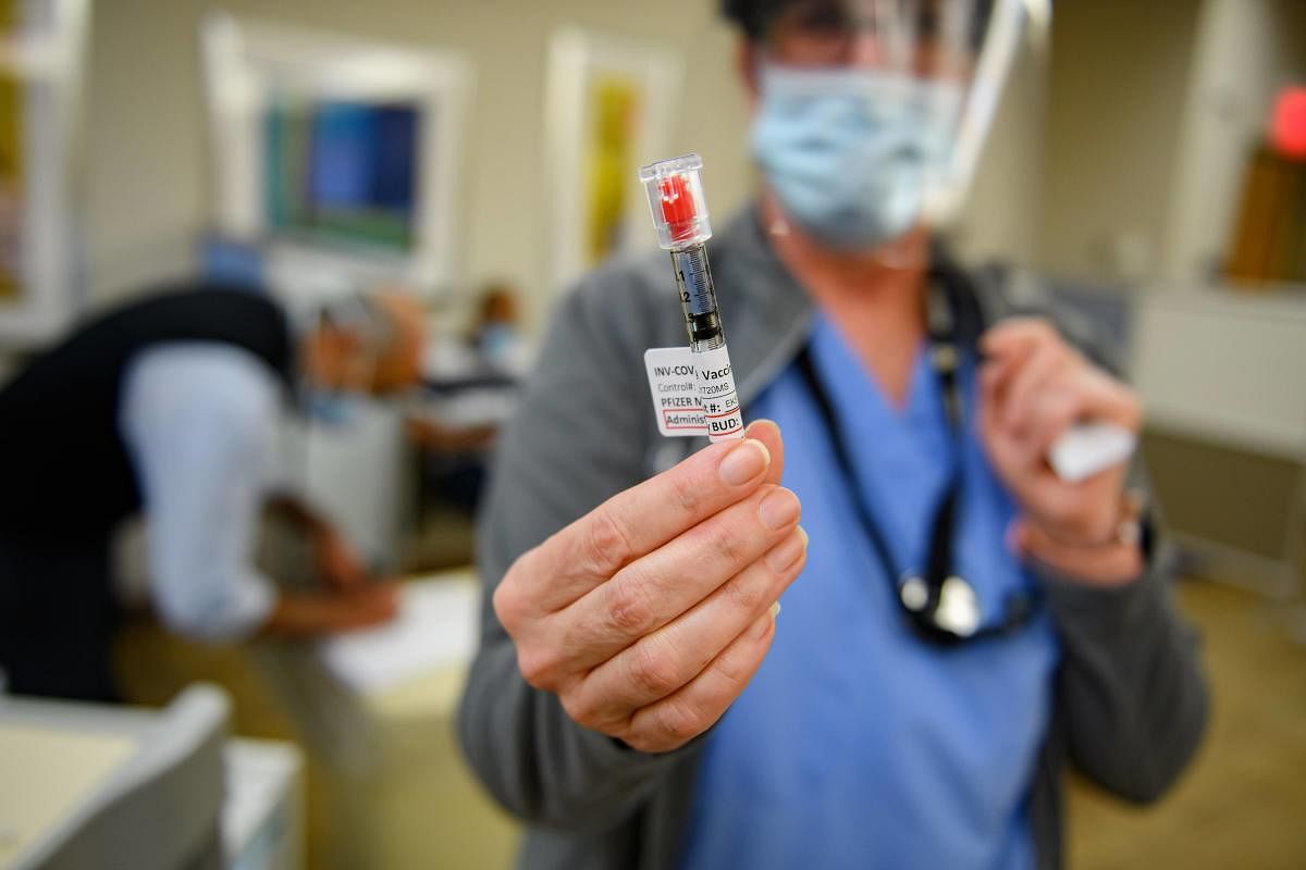 Nurse Mary Catherine Klee holds a dose of the Pzifer Covid-19 vaccine before administering it to an employee of the Pittsburgh VA Medical Center in Pittsburgh, Pennsylvania. Credit: AFP