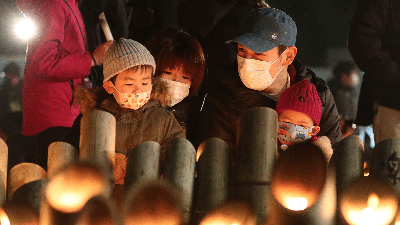 People pray for victims around candles commemorating the 26th anniversary of the Great Hanshin Earthquake at a park in Kobe, Hyogo prefecture. Credit: AFP Photo