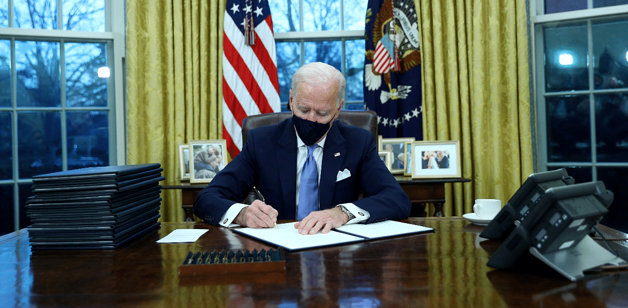 US President Joe Biden signs executive orders in the Oval Office of the White House in Washington, after his inauguration as the 46th President of the United States, US. Credit: Reuters Photo
