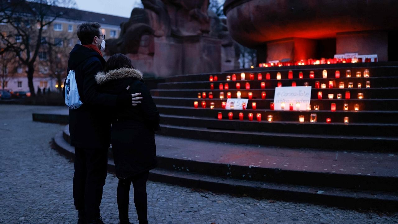 People pay their respects at a memorial site for those who have died from the novel coronavirus Covid-19 at Arnswalder Platz, in Berlin's Prenzlauer Berg district. Credit: AFP Photo.