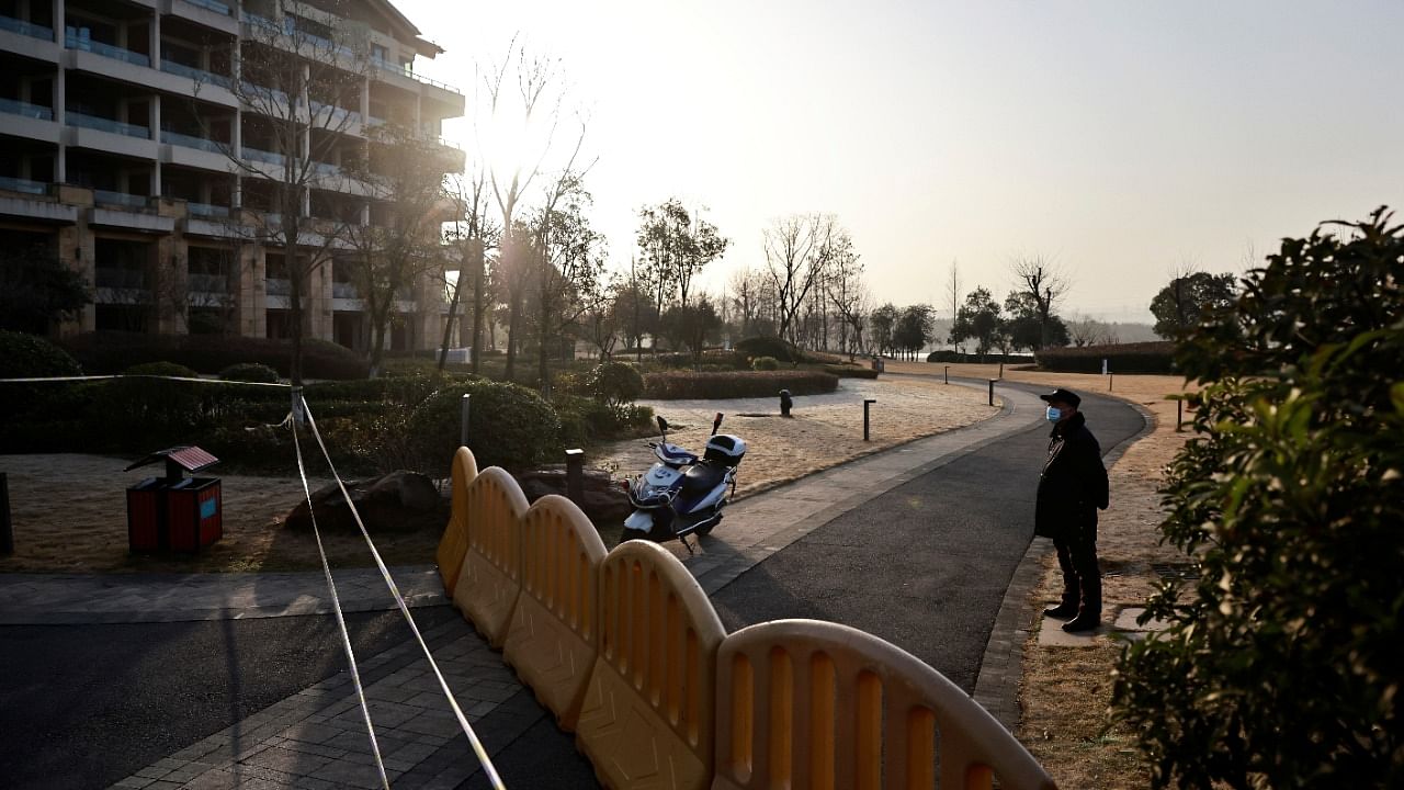 A security member keeps watch at a cordoned-off section of a hotel where members of the World Health Organization (WHO) team tasked with investigating the origins of the coronavirus disease stay, in Wuhan, Hubei province, China on January 29, 2021. Credit: Reuters Photo
