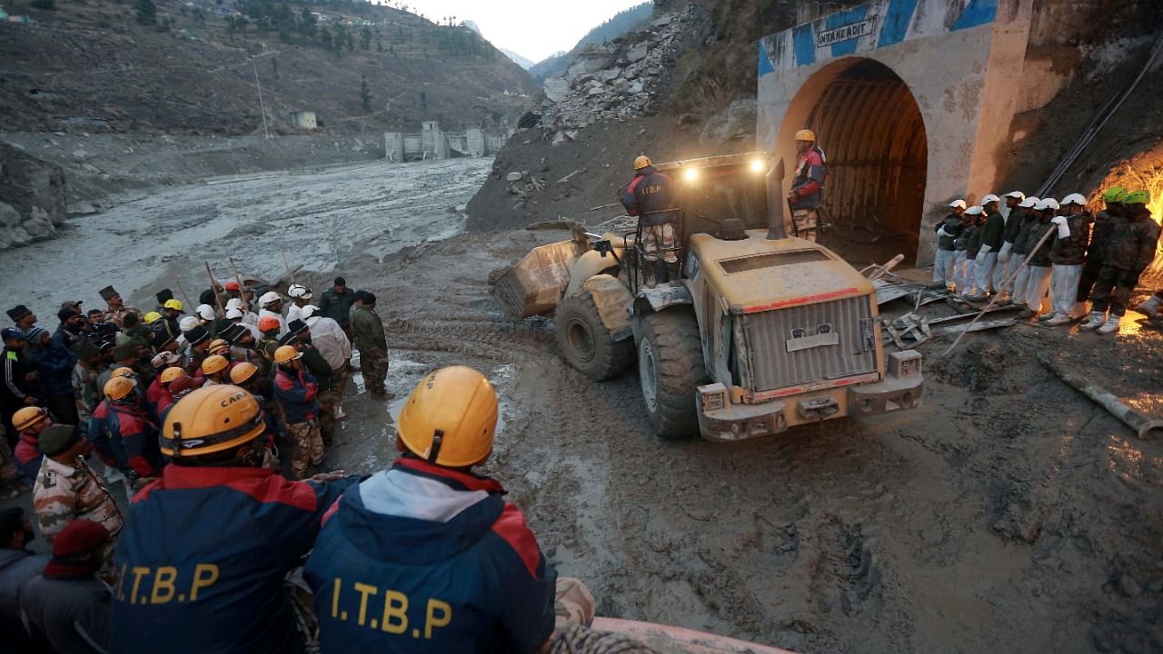 Members of Indo-Tibetan Border Police (ITBP) watch as a machine is used to clear a tunnel after a part of a glacier broke away, in Tapovan, Uttarakhand. Credit: Reuters Photo.