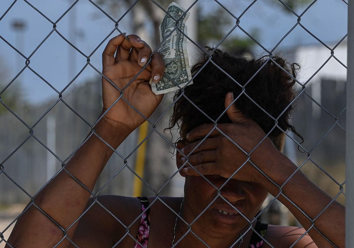 A Migrant holds a bill as she remains at the San Vicente Migrants Reception Station (SRM) in Meteti, Darien Province, in Panama. Credit: AFP photo. 