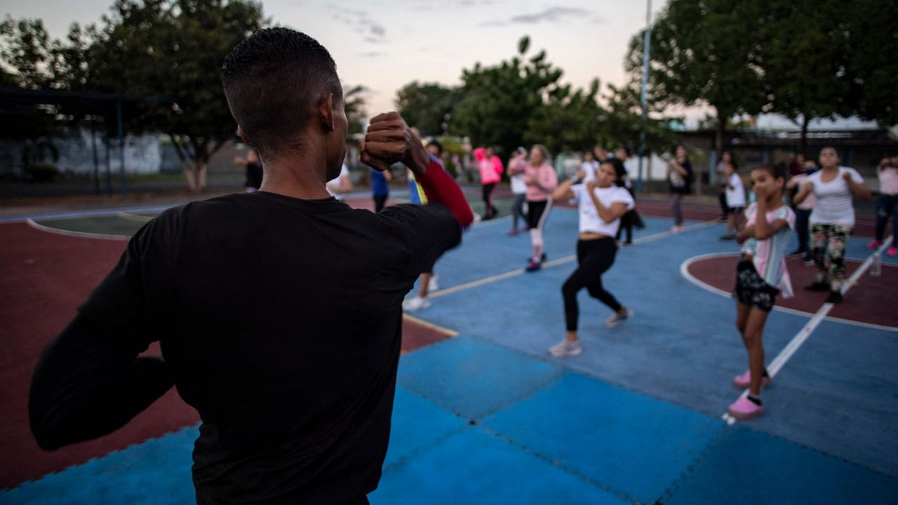 A martial arts instructor (L) teaches self-defense techniques against possible sexual offenders to women and girls at a basketball court in Acarigua, Portuguesa state, Venezuela. Credit: AFP Photo