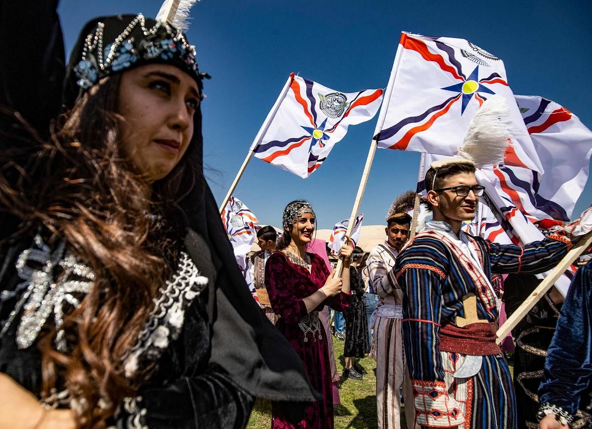 Youths dressed in traditional outfits, raise Assyrian flags as they take part in an annual parade to mark the new year, also known as Akitu, in the countryside of the town of Qahtaniya, in Syria's Hasakeh province. Credit: AFP photo.