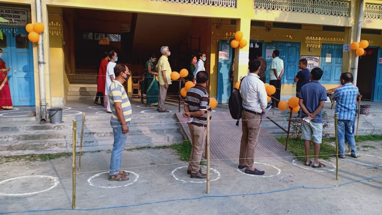 Voters maintaining covid protocol in Kokrajhar East constituency in Assam during the 3rd and final phase of polling. Credit: DH Photo