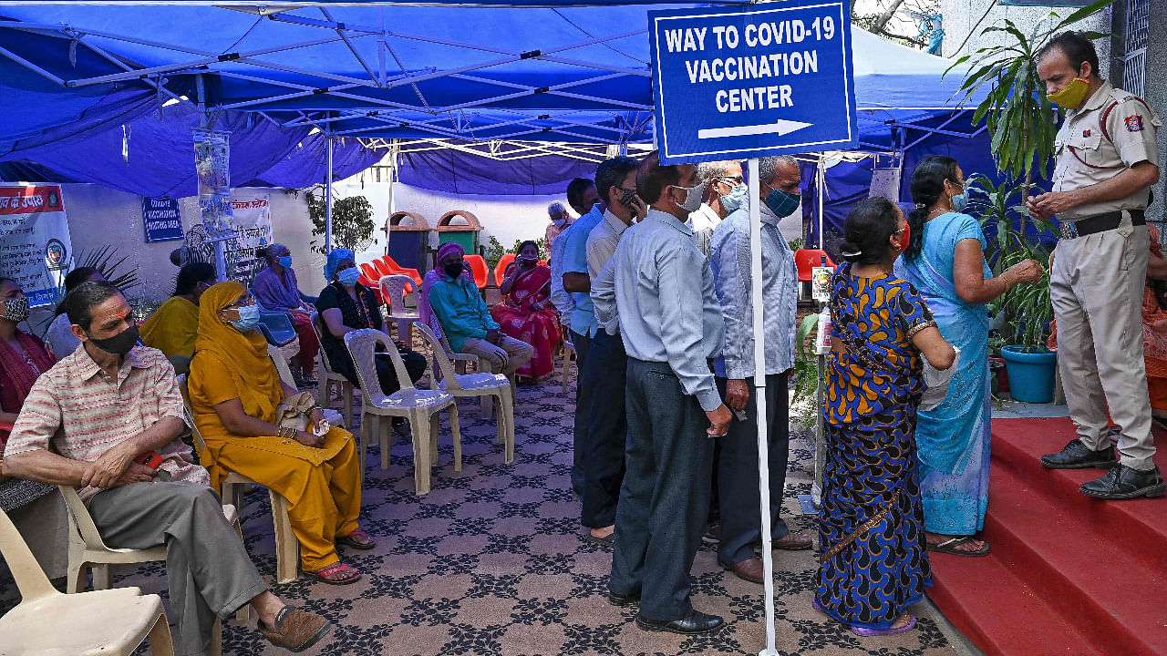 People wait in queue to receive the dose of the Covid-19 coronavirus vaccine at a health care centre in New Delhi. Delhi recently started to vaccinate people round the clock a few days ago. Credit: AFP Photo