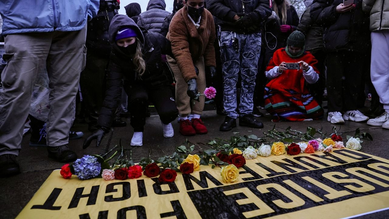 People lay flowers on a sign as they rally outside the Brooklyn Center Police Department, days after Daunte Wright was shot and killed by a police officer, days after Daunte Wright was shot and killed by a police officer, in Brooklyn Center, Minnesota. Credit: Reuters photo