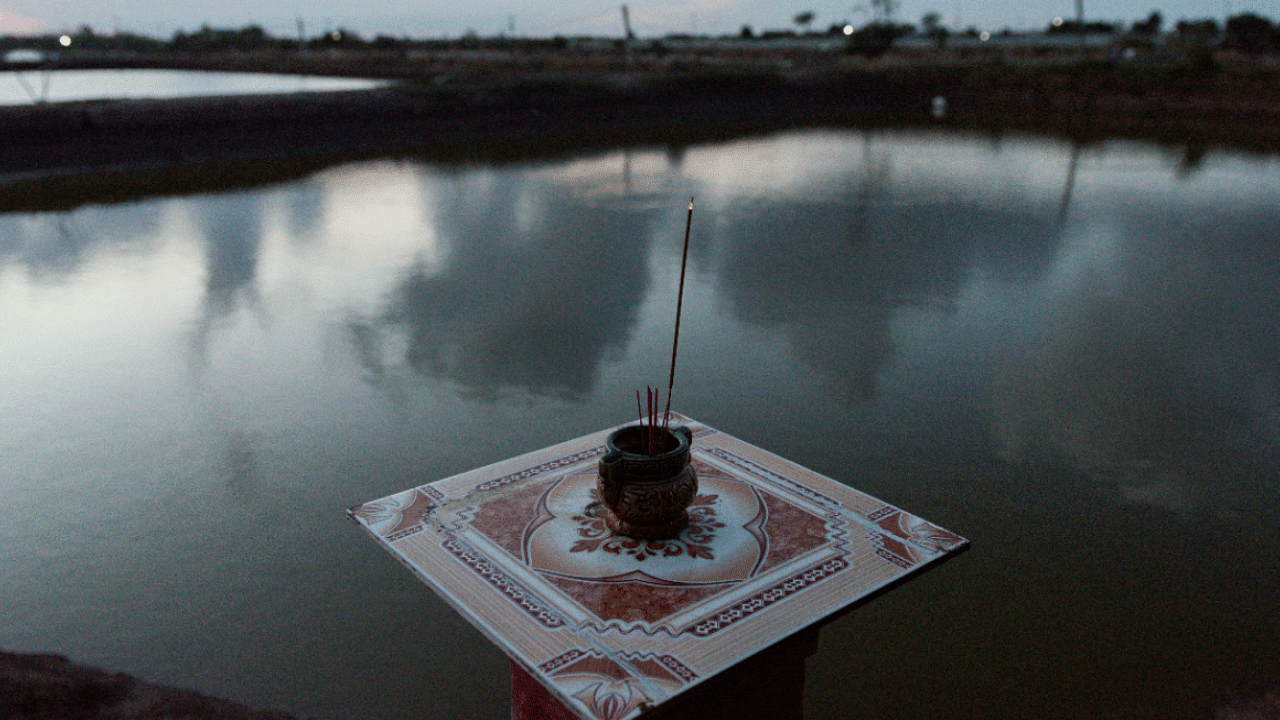 An altar is seen in front of a shrimp farm pool in Soc Trang province, Vietnam. Credit: Reuters Photo