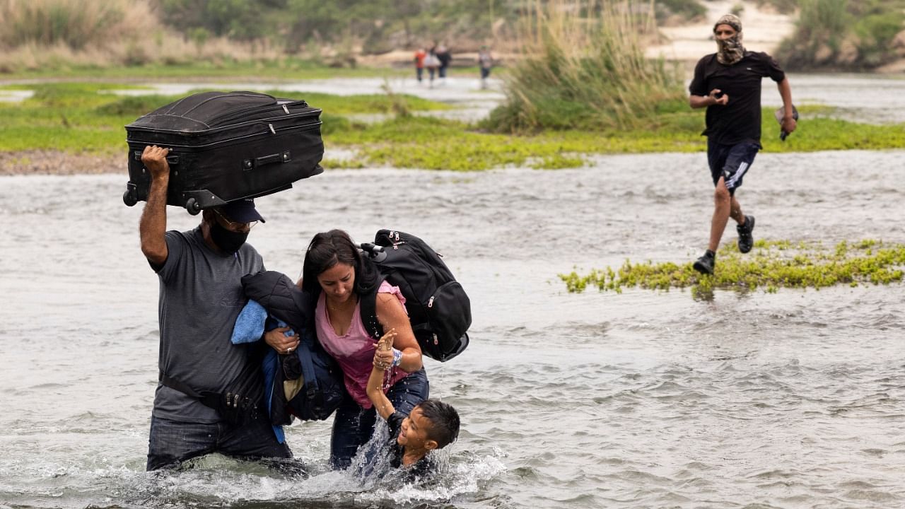 Asylum-seeking migrants from Venezuela cross the Rio Grande river into the United States from Mexico, in Del Rio, Texas, US. Credit: Reuters Photo