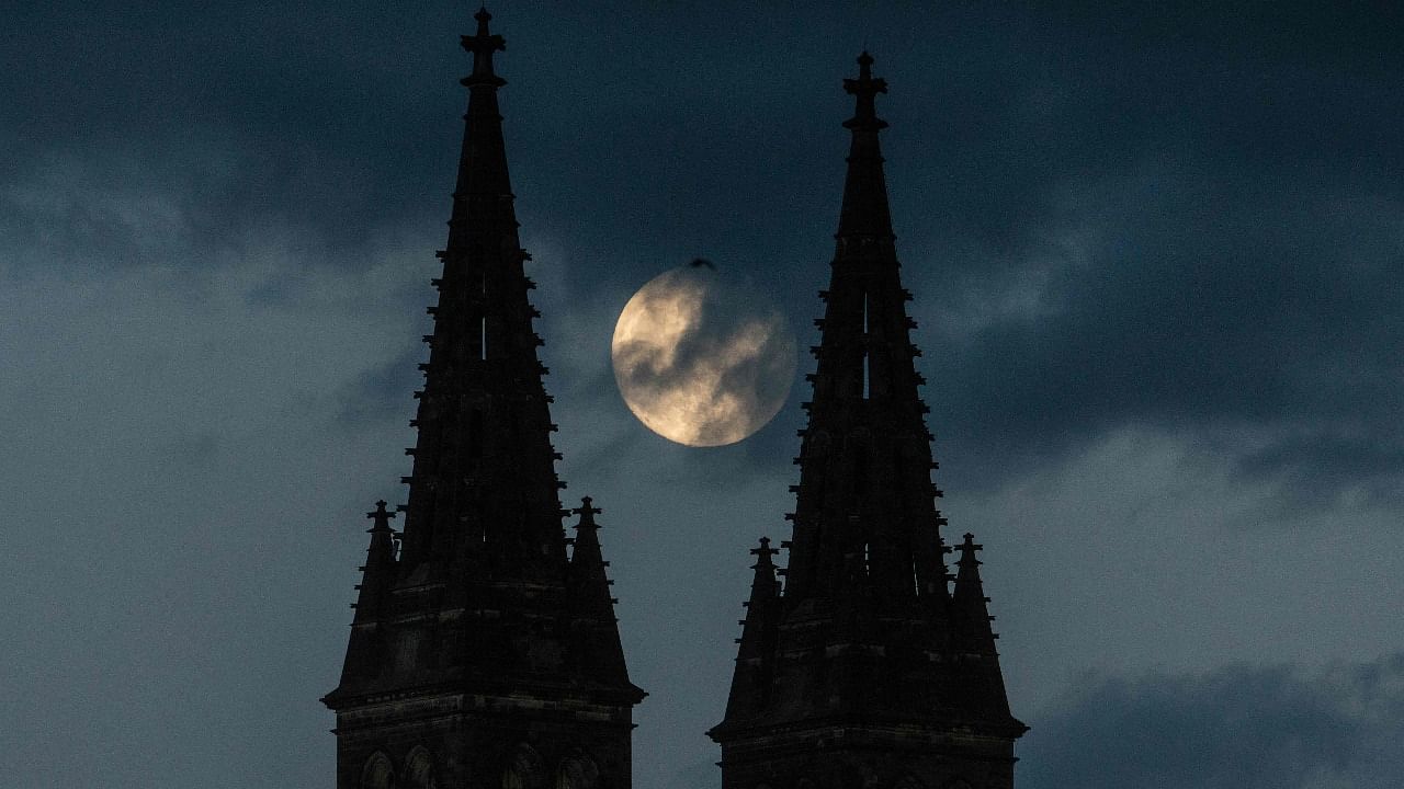 Full moon rises behind the of Basilica of St Peter and St Paul, part of Vysehrad Castle on May 25, 2021 in Prague. Credit: AFP Photo