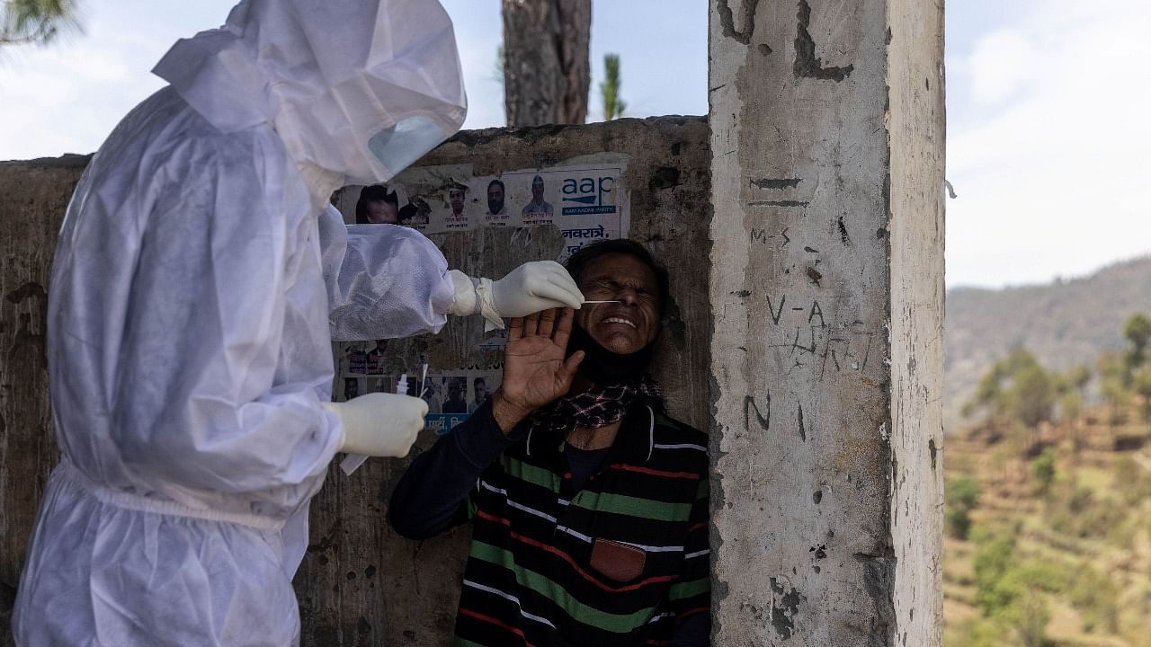 A healthcare worker wearing personal protective equipment (PPE) collects a swab sample from a man to test him for Covid-19, during the coronavirus disease (Covid-19) outbreak, at Tangroli village, in the northern state of Uttarakhand. Credit: Reuters Photo