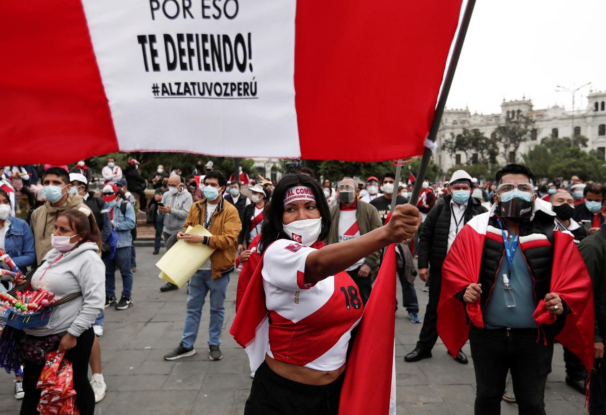 A woman waves a flag that reads "That's why I defend you. Raise your voice, Peru" while protesting against Peru's presidential candidate Pedro Castillo in a demonstration called "The Great Caravan for Peace, Liberty and Democracy," ahead of the June 6 run-off election between Castillo and Keiko Fujimori, in Lima, Peru. Credit: Reuters Photo