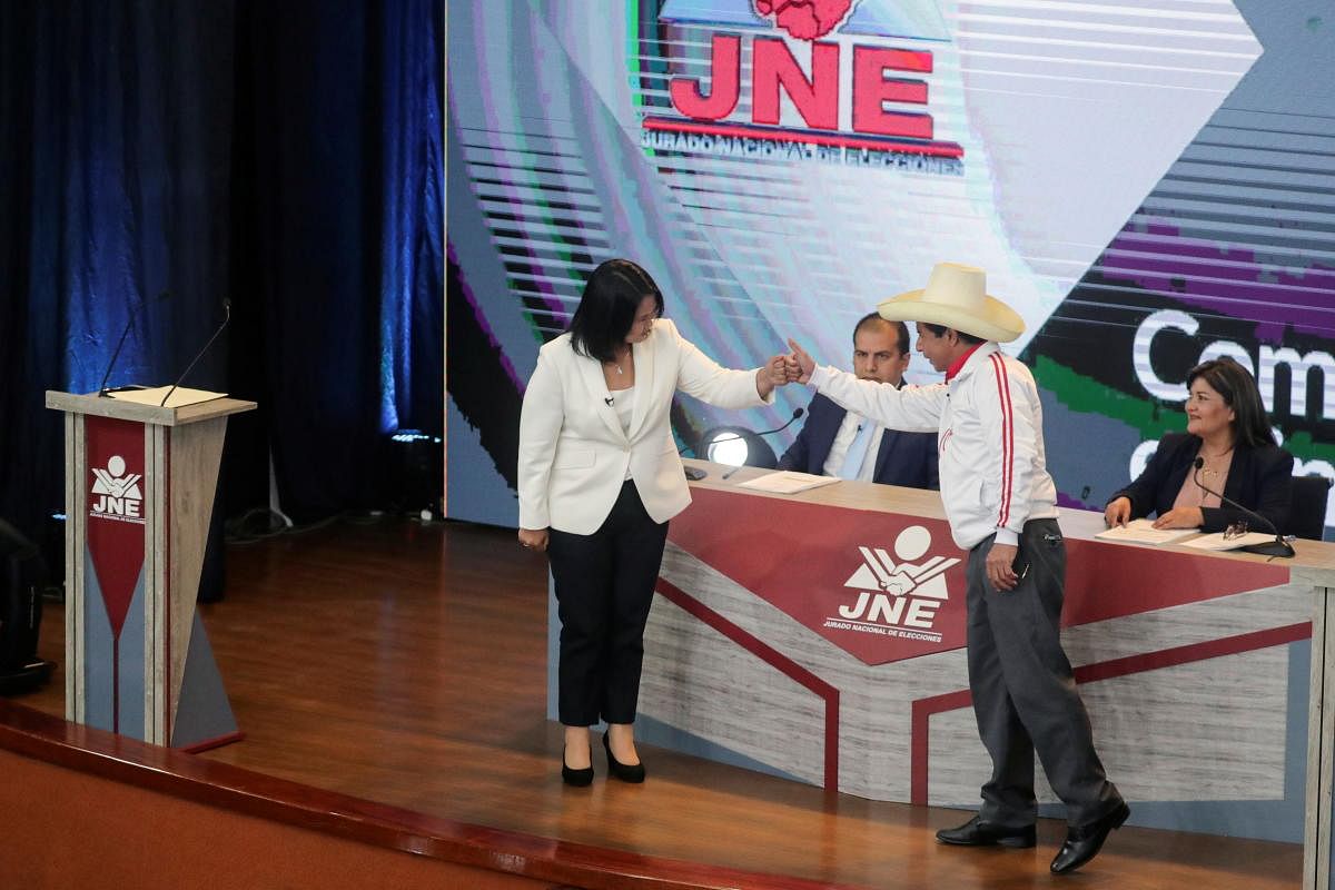 Peru's socialist candidate Pedro Castillo and his opponent, right-wing candidate Keiko Fujimori fist bump as they start their last debate ahead of the June 6 run-off election, in Arequipa, Peru. Credit: Reuters Photo