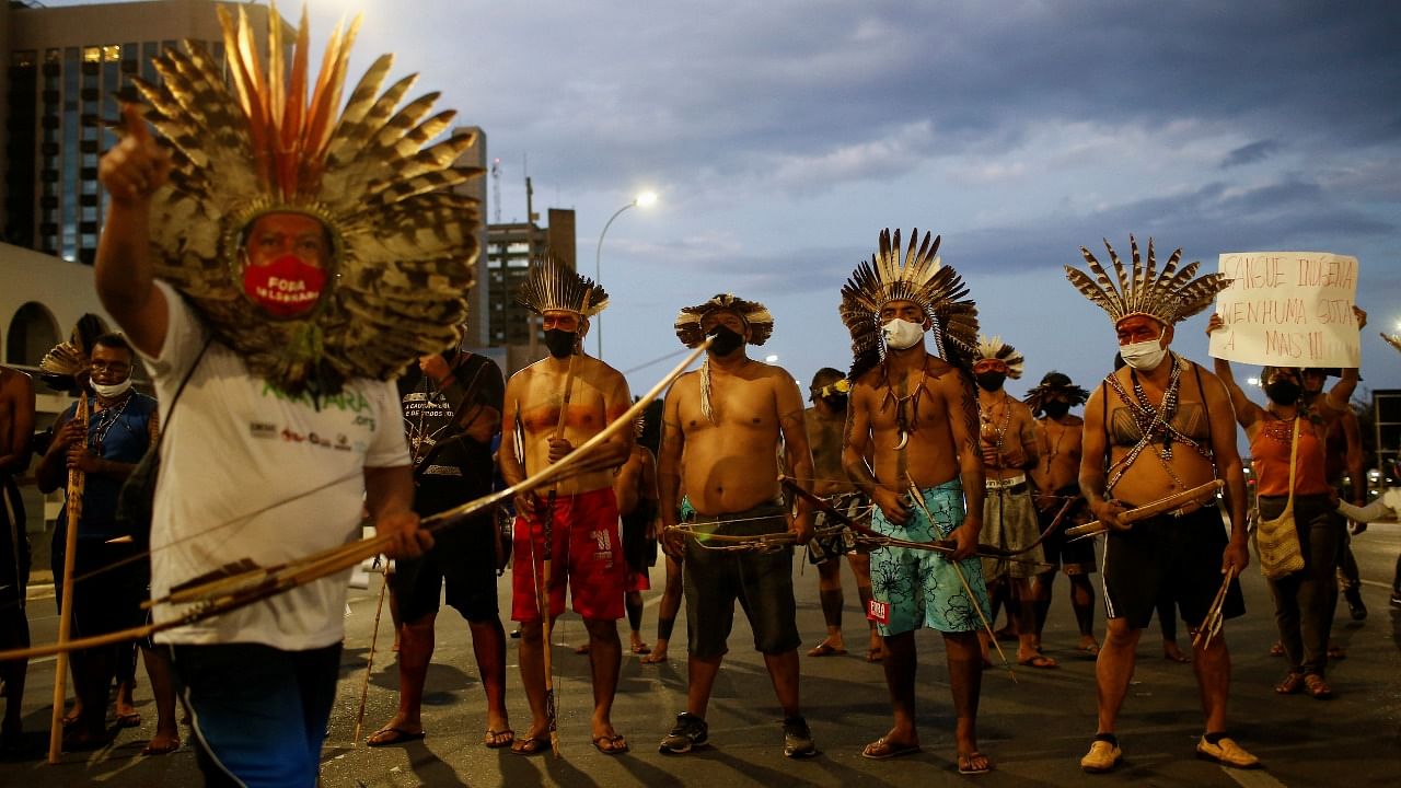 Indigenous Brazilians hold bows and arrows, as they protest their country hosting soccer Copa America tournament amid the Covid-19 pandemic and against President Bolsonaro, in Brasilia, Brazil. Credit: Reuters Photo