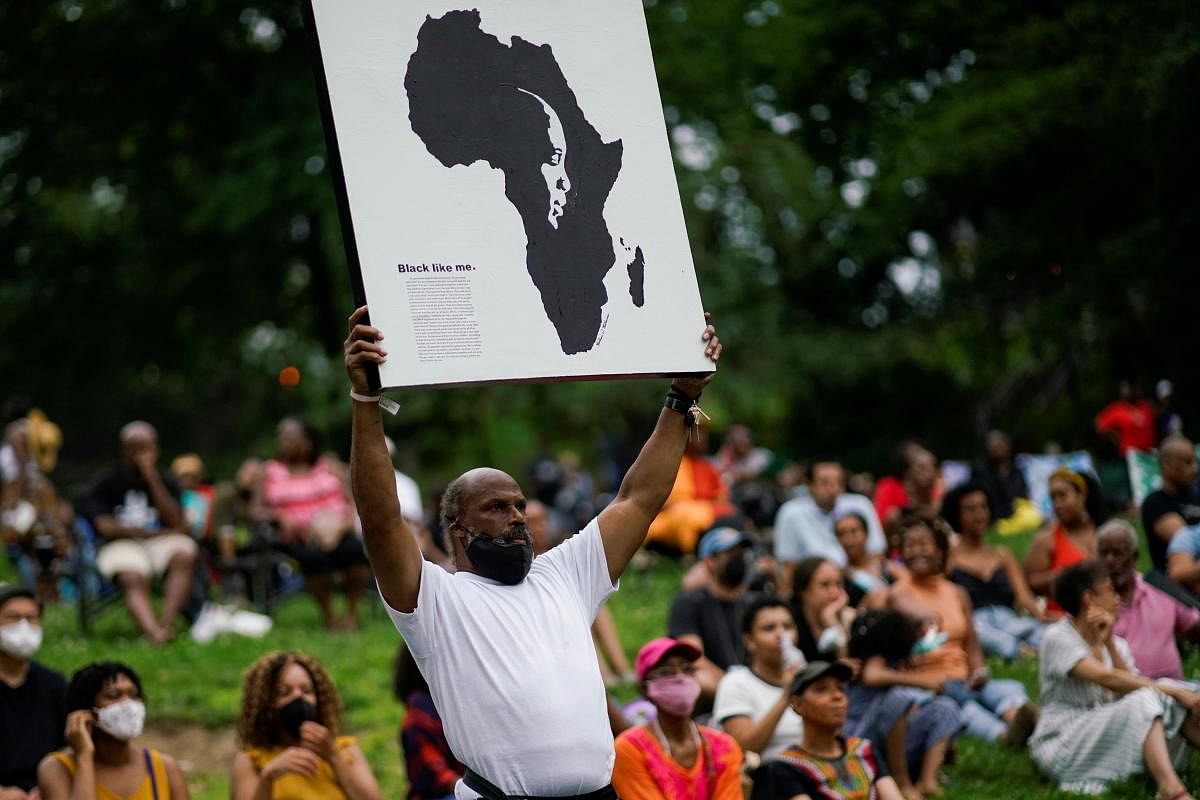 A man holds a banner as people gather at St. Nicholas Park to celebrate Juneteenth, which commemorates the end of slavery in Texas, two years after the 1863 Emancipation Proclamation freed slaves elsewhere in the United States, in New York City. Credit: Reuters Photo