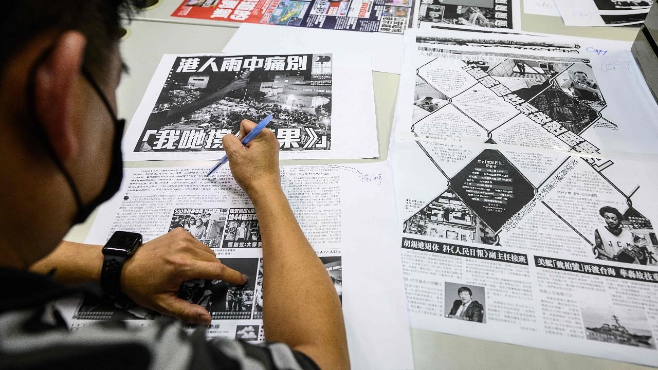 This photo taken late on June 23, 2021, shows executive editor in chief Lam Man-Chung (C) proof reading the next day's 'Apple Daily' newspaper before it goes to print for the last time in Hong Kong. Credit: AFP Photo
