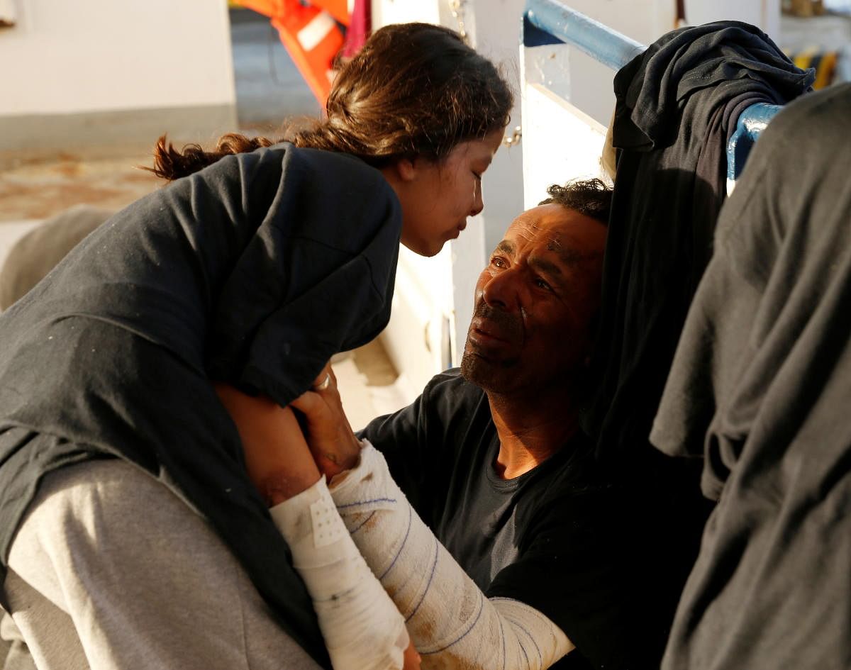 A Libyan man, who suffered severe burns when he fought a fire on a boat of migrants, talks to his daughter, also injured in the fire, on the German NGO migrant rescue ship Sea-Watch 3. Credit: Reuters Photo