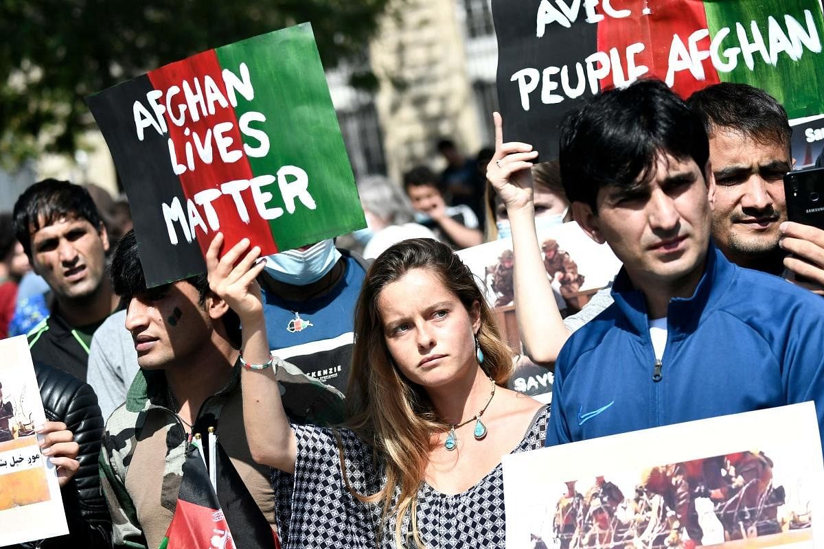 Protesters hold banners during a rally in support for Afghanistan following the take over of the country by the Taliban, at Place de la Republique in Paris. Credit: AFP Photo