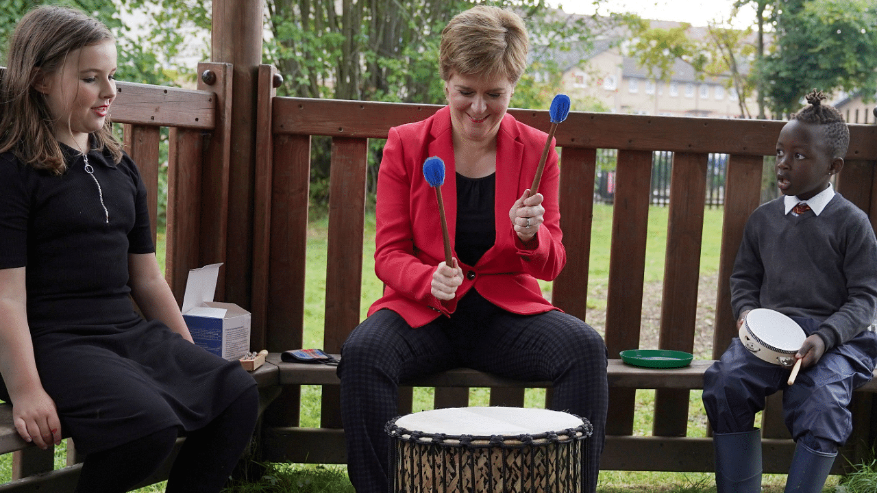 First Minister of Scotland Nicola Sturgeon plays a drum during a visit to the Indigo school-aged childcare at Castleton Primary School in Glasgow, Scotland. Credit: Reuters Photo