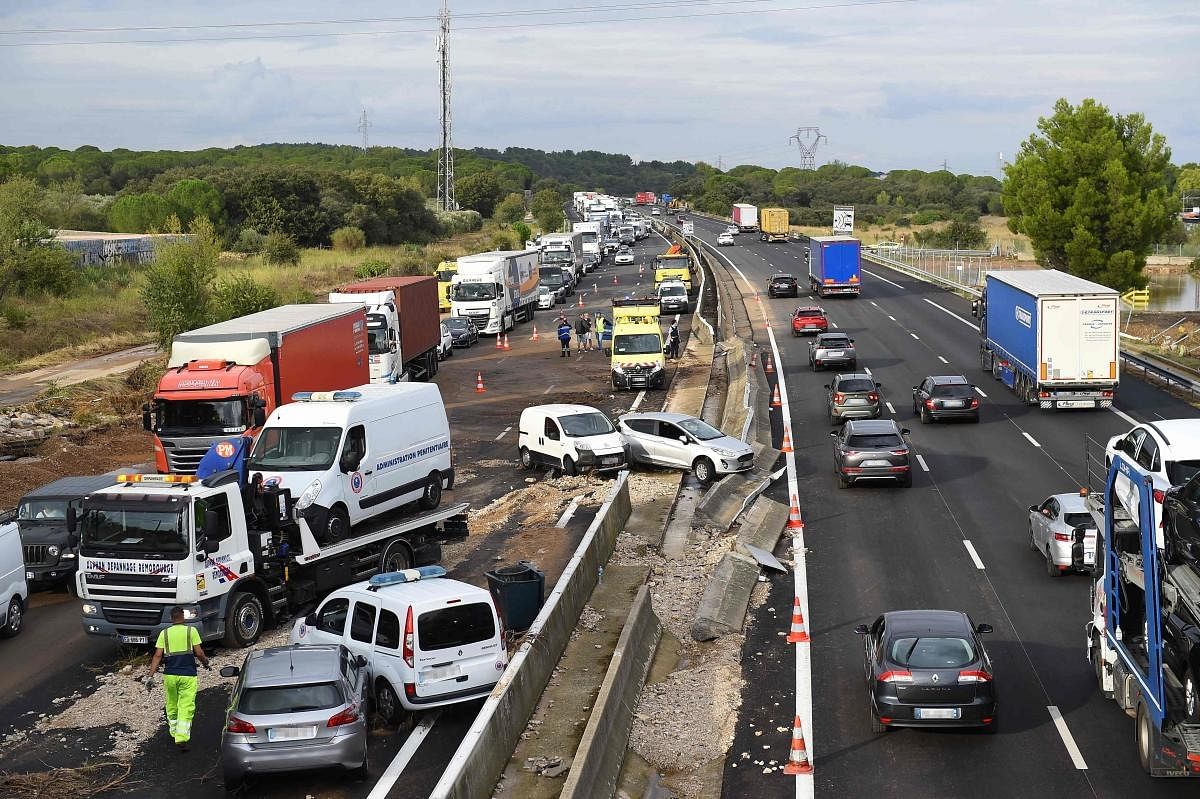Traffic flows past the wreckage of vehicles on the A9 highway, in Bernis, southern France, 2021, after heavy rains struck the region. Credit: AFP Photo