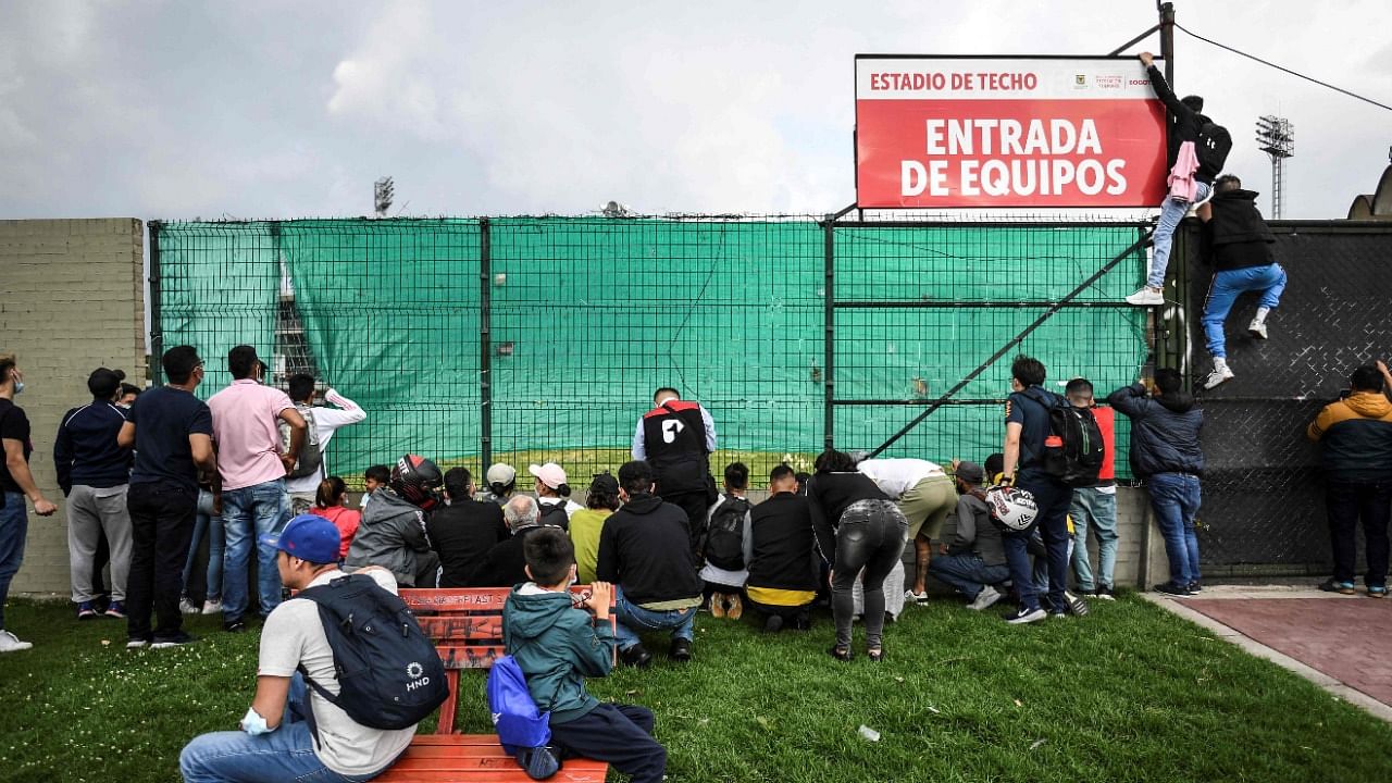 Colombian football fans try to peep Brazil's football team during their closed-door training session in Techo stadium, in Bogota. Credit: AFP Photo