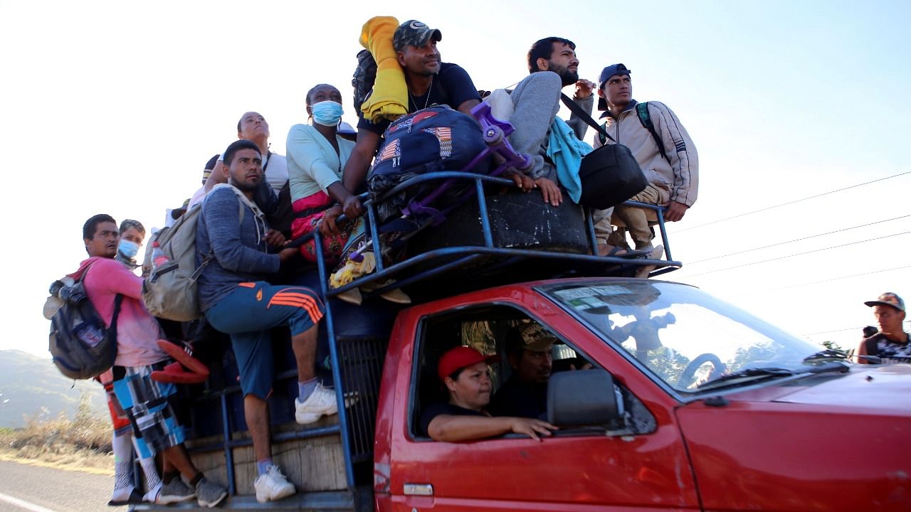 Migrants ride on a pickup truck while traveling in a caravan heading to Mexico City, in Arriaga near the border with Oaxaca state, Mexico. Credit: Reuters Photo