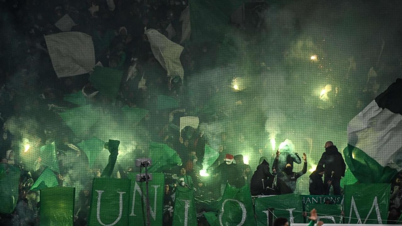 Supporters wave lighted flares during the French L1 football match between AS Saint-Etienne and FC Nantes at the Geoffrey Guichard stadium in Saint-Etienne. Credit: AFP Photo