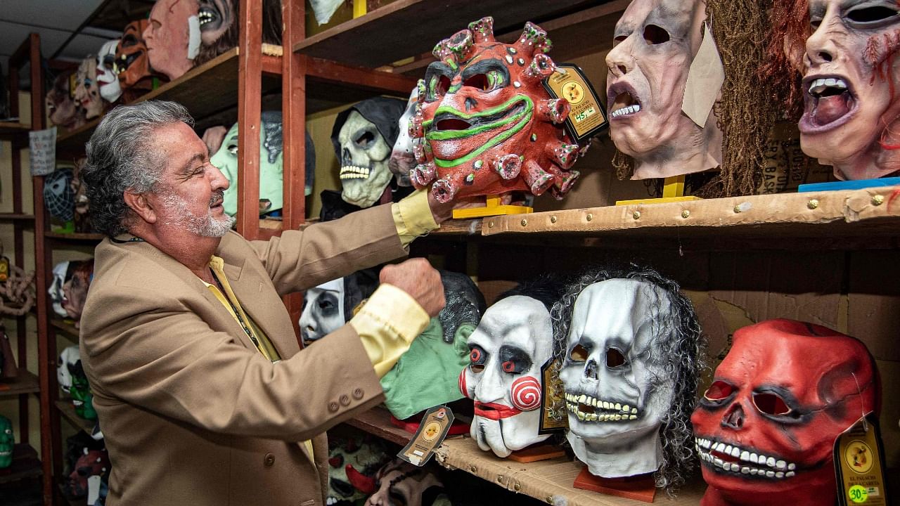 Vicente Paredes, owner of El Palacio de la Careta, checks the masks on his store in Quito. Credit: AFP Photo