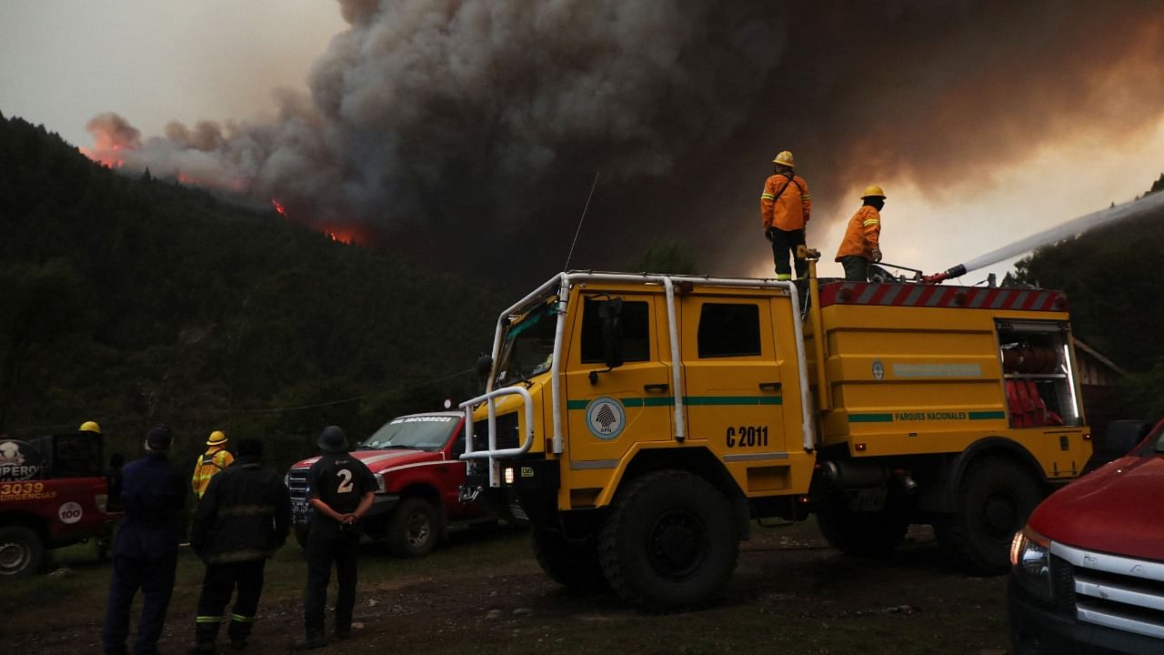 Firemen work to extinguish a fire that broke out in Paraje Villegas, Rio Negro province, 70 km south of Bariloche, Argentina. Credit: AFP Photo