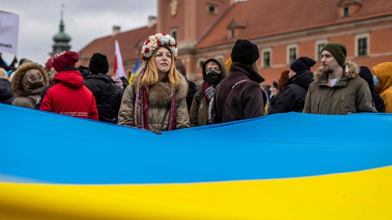 Protesters wave Ukrainian and Polish flags during a demonstration for peace in Ukraine, in Warsaw, Poland. Credit: AFP Photo